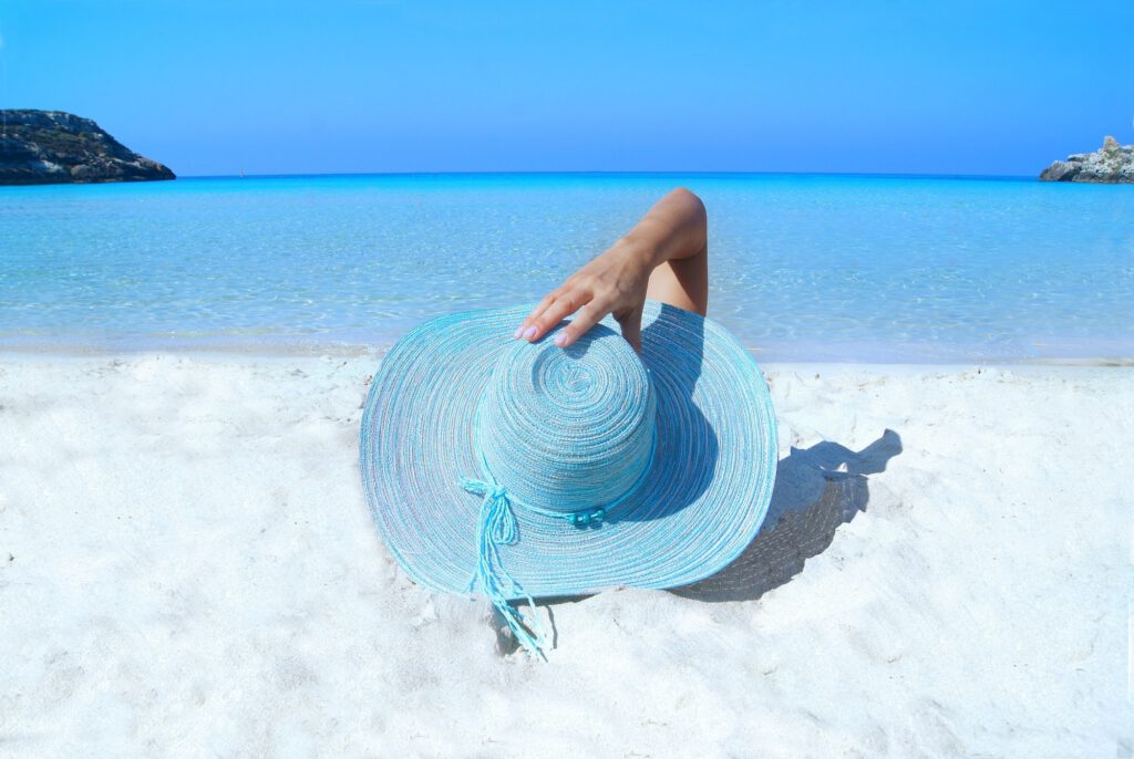 Vrouw met hoed op strand